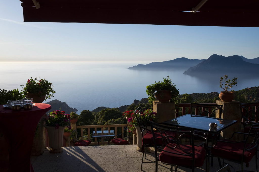Vue sur la mer d'une terrasse de restaurant à Piana, juste avant le coucher du soleil